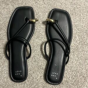 New Day black flip flops with gold toe ring